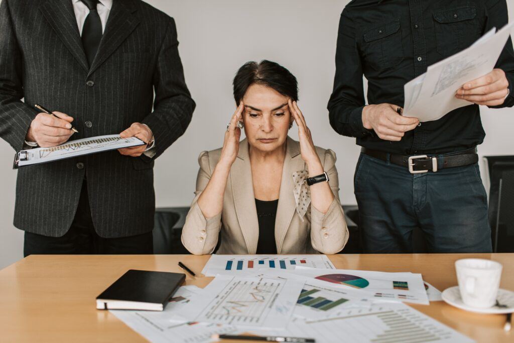 Business decision drop shipping or affiliate marketing. woman sitting between two man holding her head trying to make a decision.